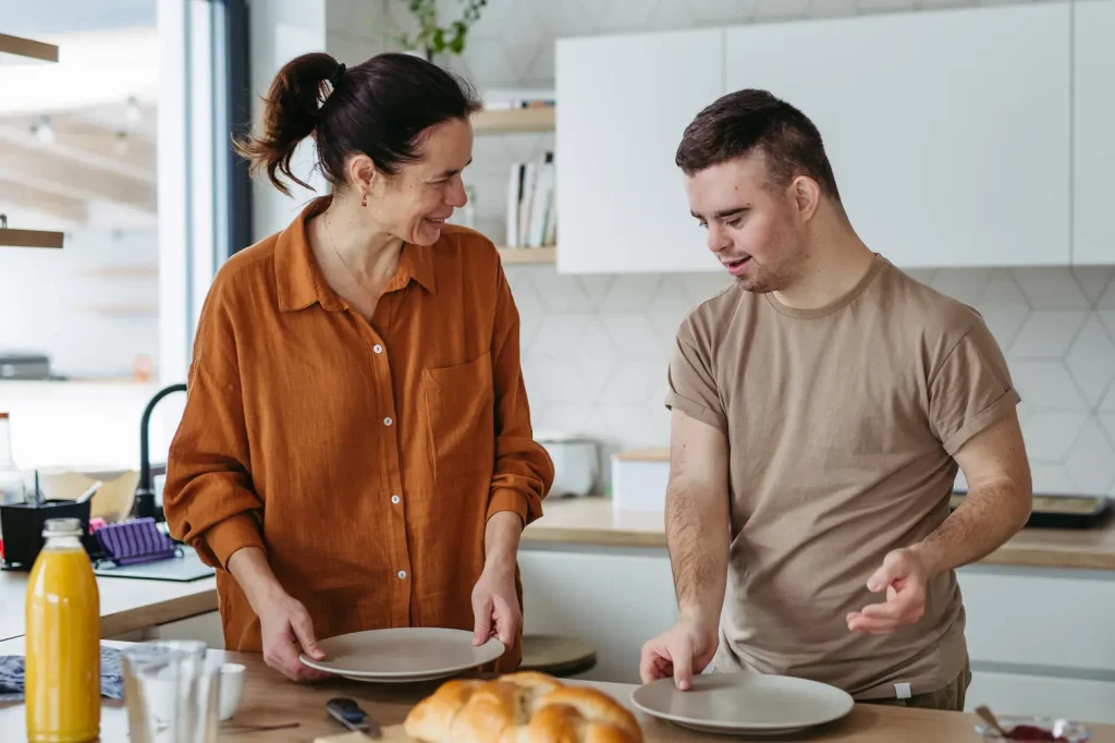 Support worker making breakfast with disabled man