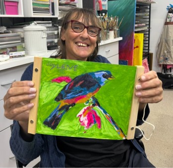 Woman holding up artwork to camera